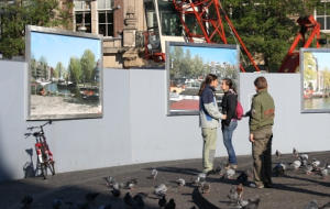 deux amoureux se tiennent devant des grandes photos